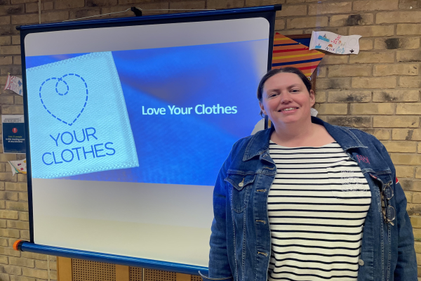 Abi Reid standing in front of a projector screen that reads 'Love your clothes'